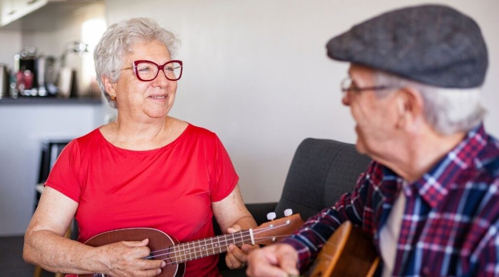Atelier de musicothérapie pour seniors en ehpad avec un intervenant jouant de la guitare
