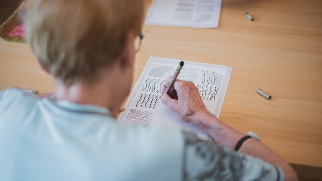 une-femme-senior-en-atelier-créatif-calligraphie