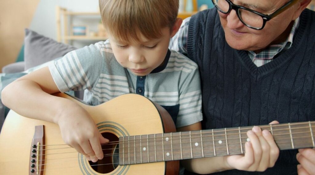 jeune-garçon-qui-joue-de-la-guitare-avec-un-résident