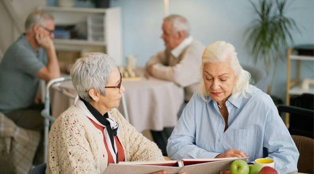 Deux-résidentes-seniors-consultant-un-document-ensemble-lors-d'un-atelier-mémoire-en-résidence