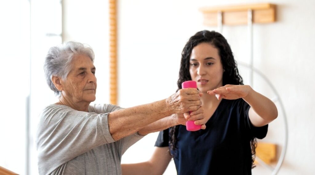 une-femme-senior-qui-pratique-gym-douce-avec-une-intervenante-coach-sportif