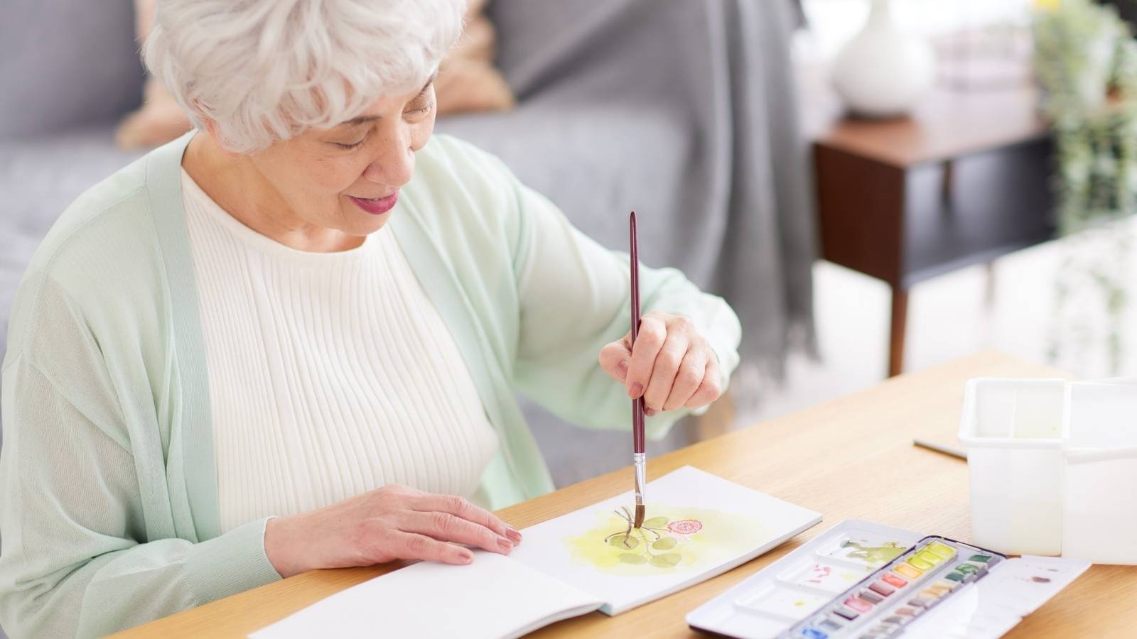 une-femme-senior-dessine-avec-la-peinture-dans-une-residence-autonomie-lors-de-l-atelier-dessin-créatif