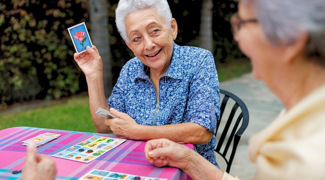une-femme-senior-joue-jeux-des-carte-en-ehpad-pour-stimuler-mémoire