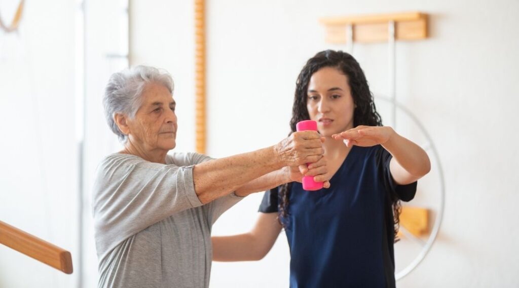 senior-accompagné-par-un-intervenant-professionnellle-pendant-un-atelier-de-gym-douce-en-résidence-autonomie