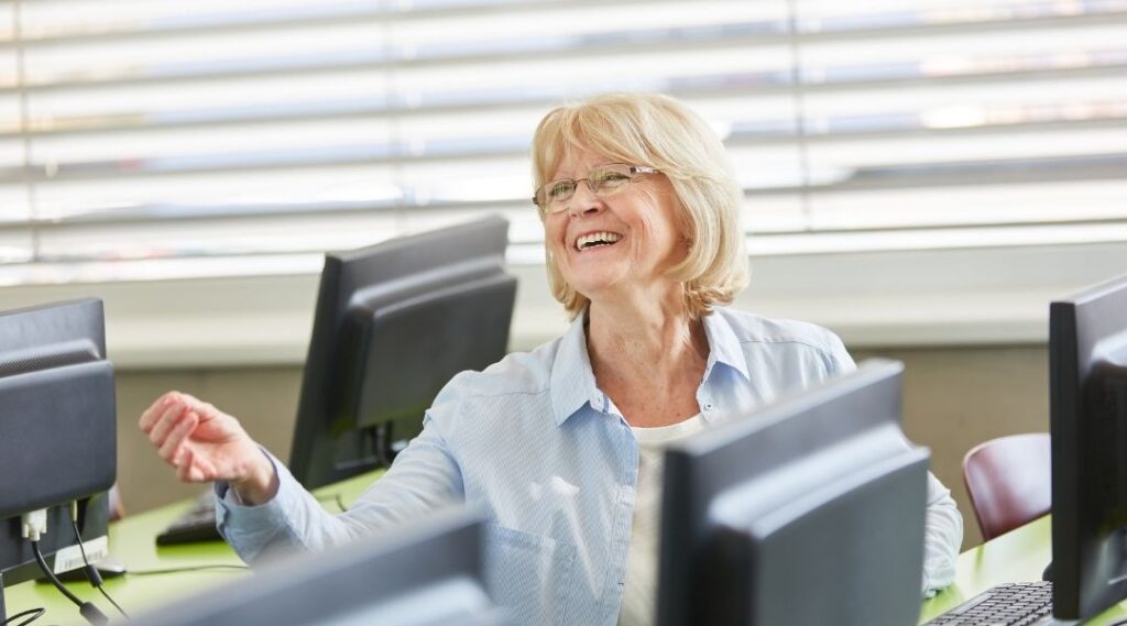 Femme-senior-souriante-participant-à-un-atelier-informatique