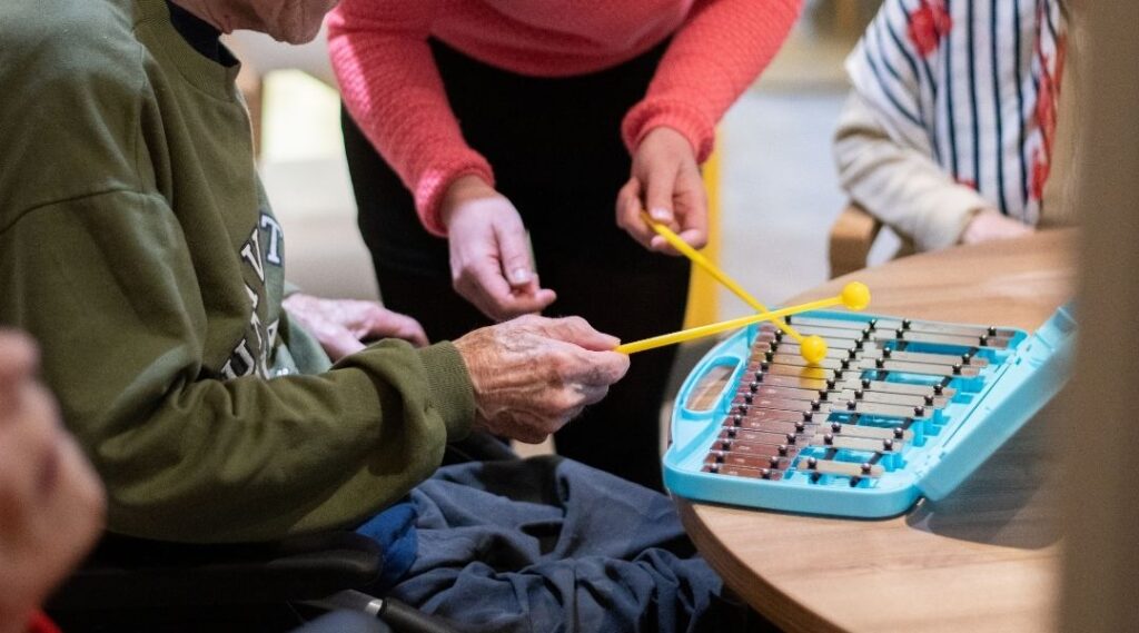 senior-jouant-d-un-instrument-de-musique-lors-d-un-atelier-de-musicotherapie-en-EHPAD