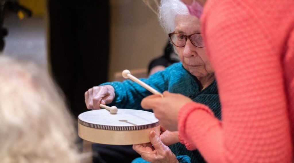 Senior-participant-à-une-séance-de-musicothérapie-en-residence-pour-personnes-âgées